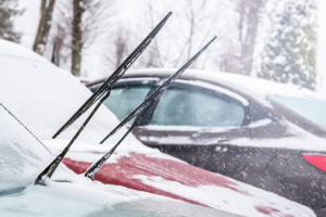 Car windshield wipers lifted up in snowy weather to prevent freezing.